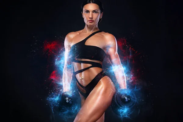 Güçlü kas vücut geliştirmeci atletik kadın siyah arka plan üzerinde dumbbells ile kasları pompalama. Egzersiz vücut geliştirme ve enerji kavramı. — Stok fotoğraf