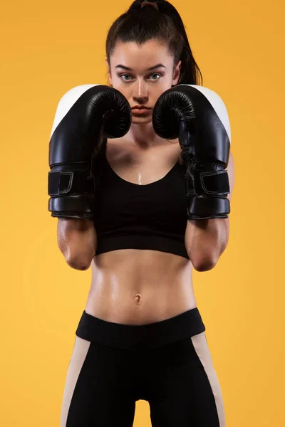 Sportember, nő bokszoló harcol a kesztyűt. a sárga háttér. Ökölvívás és fitness koncepció. — Stock Fotó