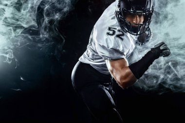 Duman ile siyah arka plan üzerinde kask Amerikan futbol sporcusu oyuncu. Spor ve motivasyon duvar kağıdı.