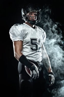 Duman ile siyah arka plan üzerinde kask Amerikan futbol sporcusu oyuncu. Spor ve motivasyon duvar kağıdı.