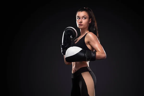 Mujer boxeadora con guantes de boxeo sobre fondo negro. Concepto de boxeo y fitness . — Foto de Stock