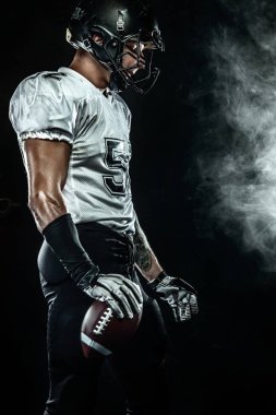 Duman ile siyah arka plan üzerinde kask Amerikan futbol sporcusu oyuncu. Spor ve motivasyon duvar kağıdı.