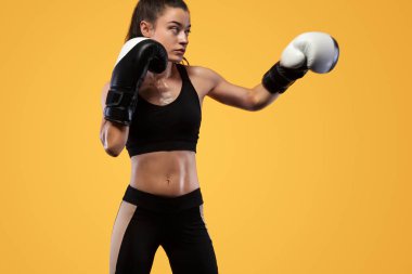 Sporcu, eldiven giymiş kadın boksörü. sarı arka planda. Boks ve fitness konsepti.