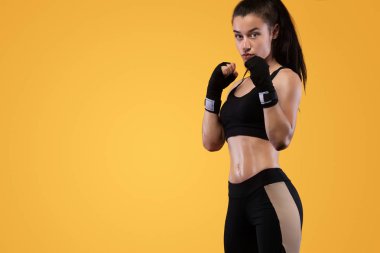 Sporcu, eldiven giymiş kadın boksörü. sarı arka planda. Boks ve fitness konsepti.