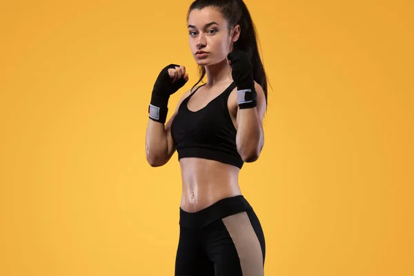 Deportista, boxeadora peleando con guantes. sobre fondo amarillo. Concepto de boxeo y fitness . — Foto de Stock