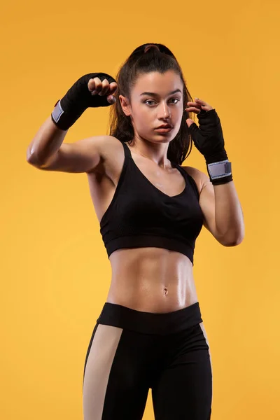 Deportista, boxeadora peleando con guantes. sobre fondo amarillo. Concepto de boxeo y fitness . — Foto de Stock