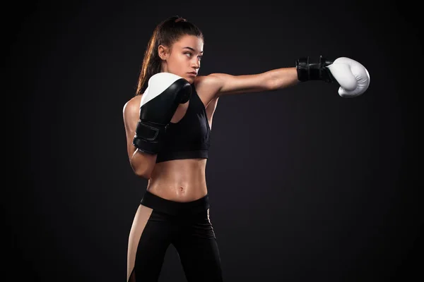 Mujer boxeadora con guantes de boxeo sobre fondo negro. Concepto de boxeo y fitness . —  Fotos de Stock