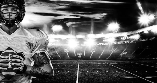 Jucător american de fotbal, sportiv în cască pe stadion. Fotografie alb-negru. Tapet sport . — Fotografie, imagine de stoc