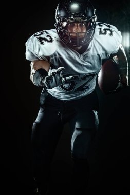 Duman ile siyah arka plan üzerinde kask Amerikan futbol sporcusu oyuncu. Spor ve motivasyon duvar kağıdı.