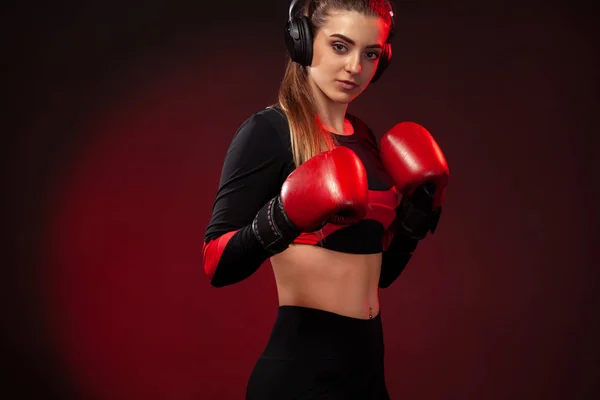 Mujer joven deportista boxeadora en entrenamiento de boxeo. Chica usando guantes, ropa deportiva . — Foto de Stock