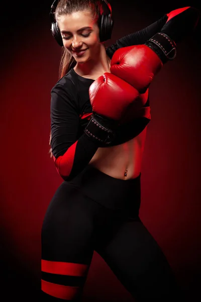 Feliz y sonriente joven boxeadora deportista en entrenamiento de boxeo. Chica usando guantes, ropa deportiva . — Foto de Stock