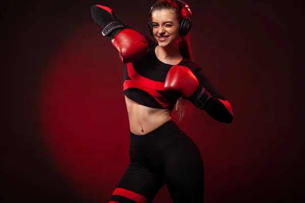 Счастливая и улыбающаяся молодая женщина боксер-спортсмен на боксерской тренировке. Девушка в перчатках, спортивной одежде . — стоковое фото