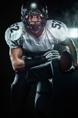Duman ile siyah arka plan üzerinde kask Amerikan futbol sporcusu oyuncu. Spor ve motivasyon duvar kağıdı.