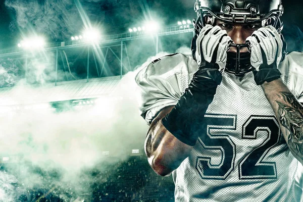 Jogador de futebol americano. Esportista com bola no capacete no estádio em ação. Papel de parede esporte. Retrato de close-up . — Fotografia de Stock