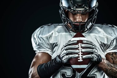 Kask lı Amerikalı futbolcu siyah arka planda hareket halinde. Spor ve motivasyon duvar kağıdı. Takım sporları,