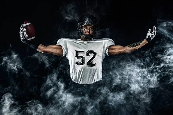 American Football Sportler mit Helm isoliert Lauf in Aktion auf schwarzem Hintergrund. Sport und Motivation Tapete. Mannschaftssport, — Stockfoto