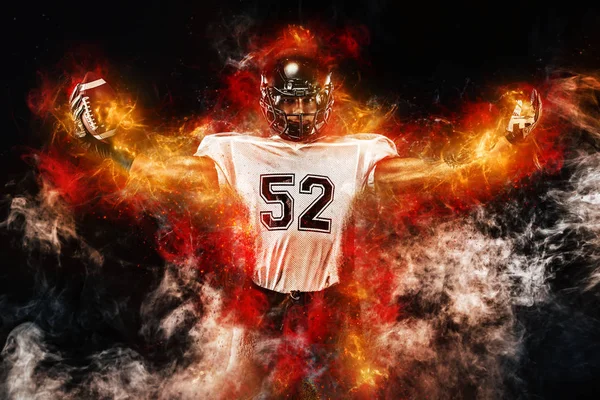 American football player in helmet, on the stadium field with ball in the hand. Fire background. Team sports. Sport wallpaper.
