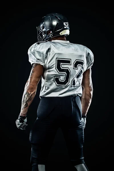 Американський футболіст футболіста в шоломі на чорному фоні. Спорт і мотивація. Командні види спорту. — стокове фото