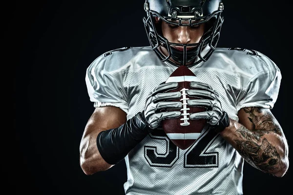 Giocatore sportivo di football americano in casco su sfondo nero. Sport e motivazione. Sport di squadra . — Foto Stock