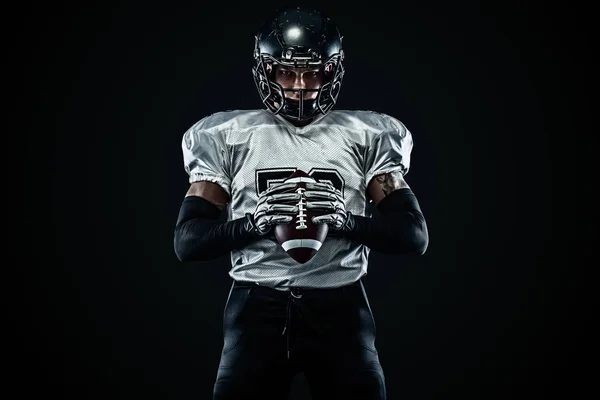 Giocatore sportivo di football americano in casco su sfondo nero. Sport e motivazione. Sport di squadra . — Foto Stock