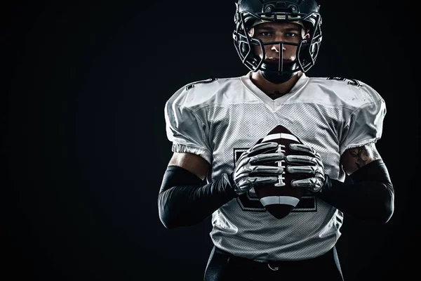 American Football Sportler mit Helm auf schwarzem Hintergrund. Sport und Motivation. Mannschaftssport. — Stockfoto