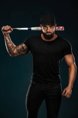 Siyah t-shirt beyzbol sopası ile güçlü ve fit adam vücut geliştirmeci. Sportif kaslı adam atlet. Spor ve fitness konsepti. Erkek modası.