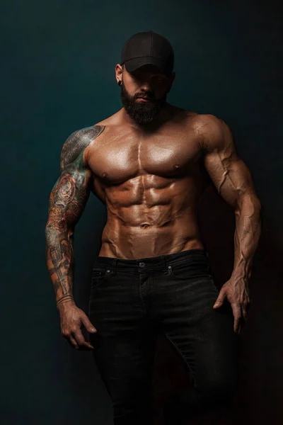 Strong and fit man bodybuilder bare-chested in black baseball cap. Sporty muscular guy athlete. Sport and fitness concept. Mens fashion. — Stock Photo, Image