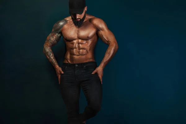 Sterke en fit man bodybuilder kale-chested in zwarte Baseballpet. Sportieve gespierde kerel atleet. Sport-en fitness concept. Mens Fashion. — Stockfoto