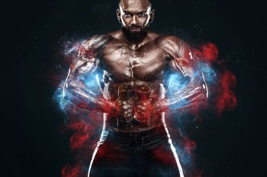 Güçlü ve zinde adam vücut geliştirmeci. Dambıllı sportif kaslı adam. Spot ve fitness motivasyonu. Anka kuşu gibi yanan adam.