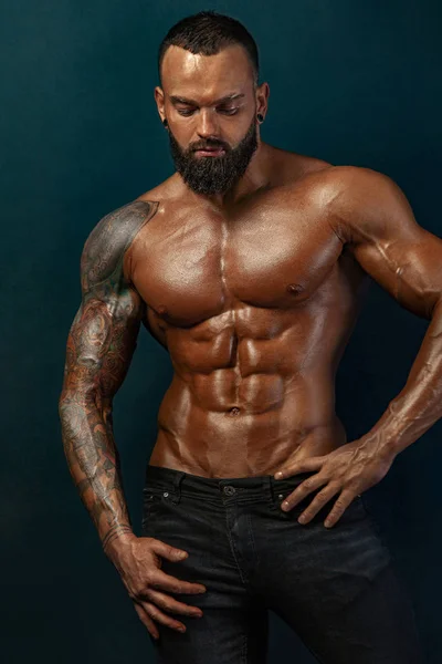 Güçlü ve zinde adam vücut geliştirmeci. Sportif kaslı adam atlet. Spor ve fitness konsepti. Erkek modası.