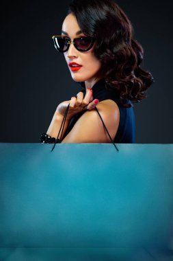 Kara Cuma satış konseptinin yakın plan portresi. Güneş gözlüklü bir kadın büyük bir çanta taşıyor..