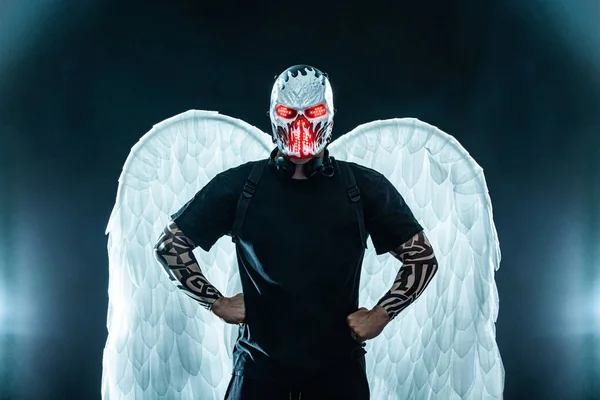 Mysterious man in black wear and skull mask with white wings. Fantasy book or computer game cover concept on halloween party. — Stock Photo, Image