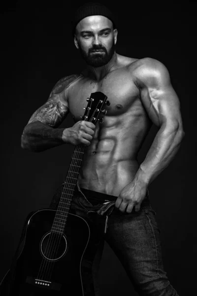 Сильний і пристосований до людини культурист з гітаром показує черевний м'яз. Спортивний м'язистий спортсмен. Спортивна та фітнес-концепція. Чоловіча мода . — стокове фото
