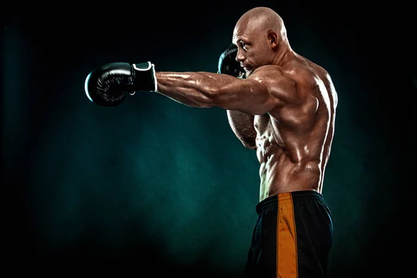 Sportovec, muž boxer bojující v rukavicích na černém pozadí. Koncept fitness a boxu. Individuální sportovní rekreace. — Stock fotografie