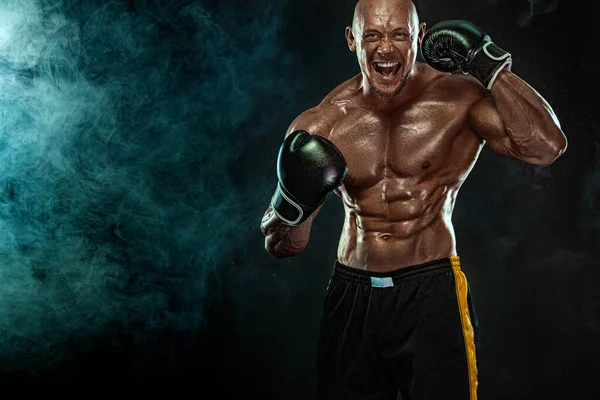 Deportista, hombre boxeador luchando con guantes sobre fondo negro. Concepto de fitness y boxeo. Acción de disparar. Recreación deportiva individual . — Foto de Stock