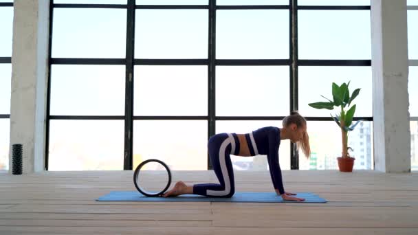 Yoga drinnen. Sportliche Erholung. schöne junge Frau in Asana mit Yoga-Ring für Anfänger. Individuelle Sportarten. Zimmer mit großem Panoramafenster. — Stockvideo