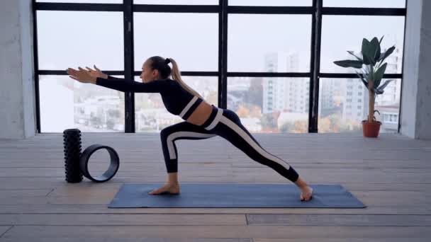 Yoga inomhus. Sportrekreation. Vacker ung kvinna i asana med yoga ring för nybörjare. Enskilda sporter. Rum med stort panoramafönster. — Stockvideo