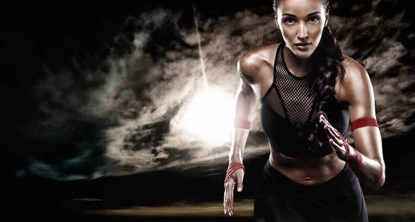 Forte athlète femme sprinteuse, fonctionnant sur fond sombre vêtue de vêtements de sport. Fitness et motivation sportive. Concept de coureur . — Photo