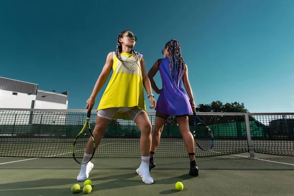 Femme joueuse de tennis posant comme un mannequin de fitness sur un court de tennis. — Photo