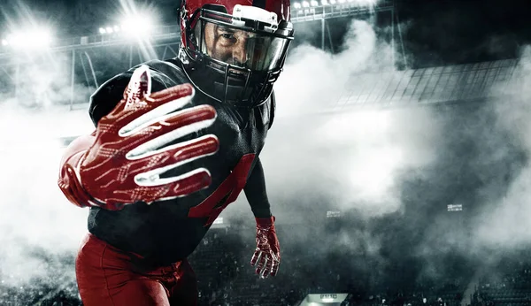 Jugador de fútbol americano, deportista atleta en casco rojo sobre fondo oscuro con humo. Fondo de pantalla deporte y motivación. —  Fotos de Stock