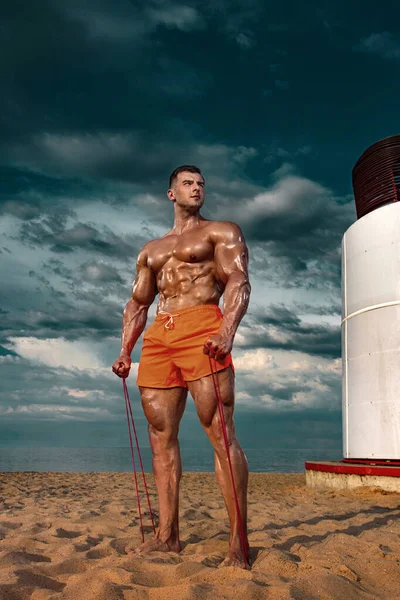 Fit Sportler Bodybuilder am Strand. Attraktiver junger Bademeister in der Nähe des Aussichtsturms am Strand. — Stockfoto