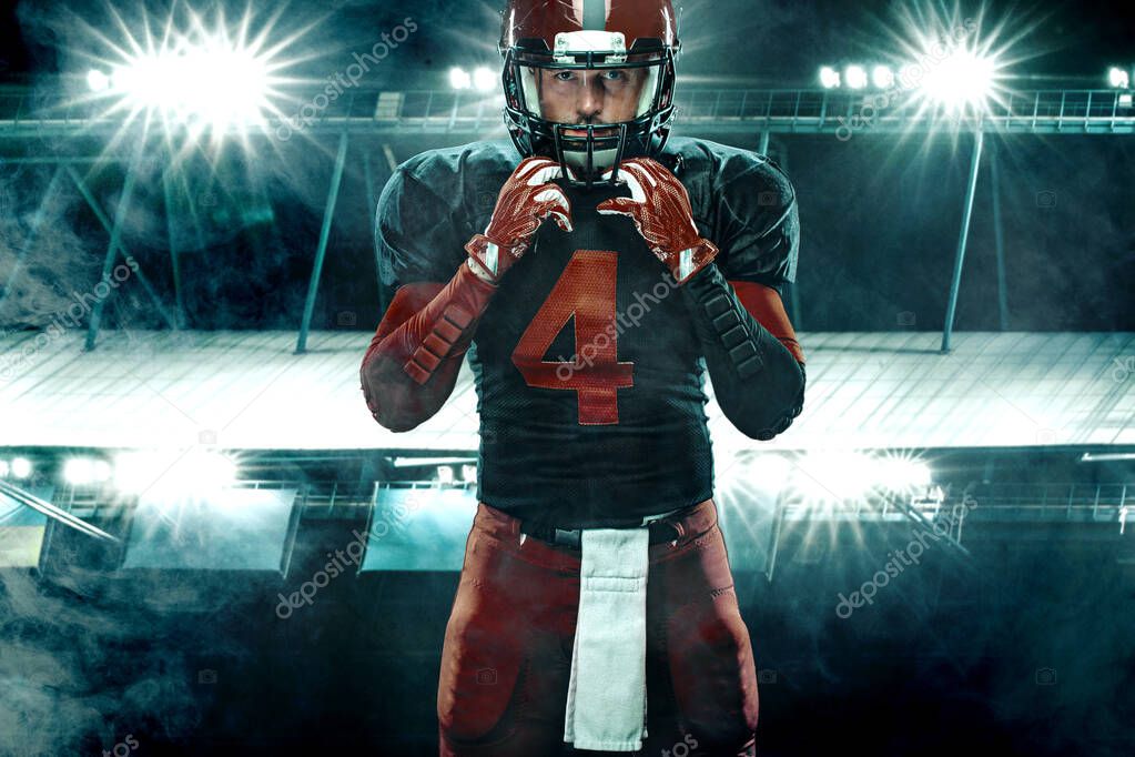 Closeup portrait of american football player, athlete sportsman in red helmet on grand arena background. Sport and motivation wallpaper.