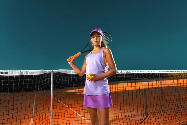 Joueur de tennis. Belle adolescente et athlète avec raquette en vêtements de sport rose et chapeau sur le court de tennis. Concept mode et sport. — Photo