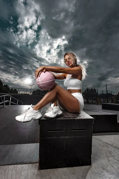 Bella e sexy donna in forma in abito con una palla da basket. Concetto moda sport e abbigliamento sportivo — Foto Stock