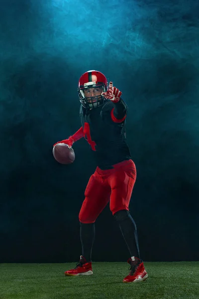 アメリカのサッカー選手、煙と暗い背景に赤いヘルメットのアスリートスポーツマン。スポーツ&モチベーション壁紙. — ストック写真