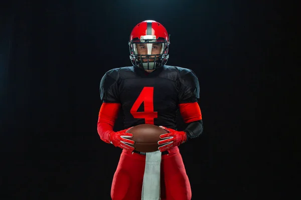 Giocatore di football americano, atleta sportivo in casco rosso su sfondo nero. Sport e motivazione carta da parati. — Foto Stock