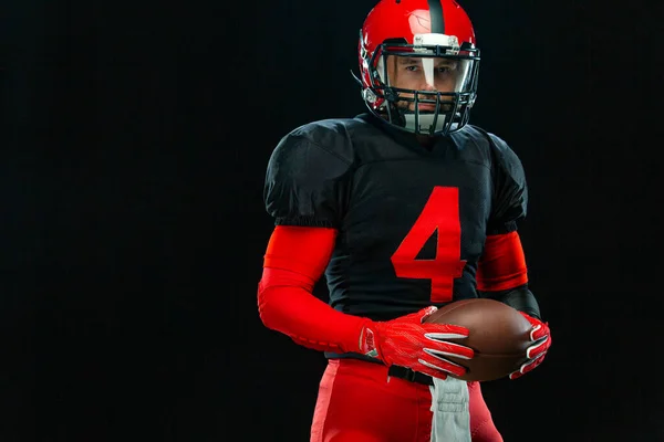 Giocatore di football americano, atleta sportivo in casco rosso su sfondo nero. Sport e motivazione carta da parati. — Foto Stock