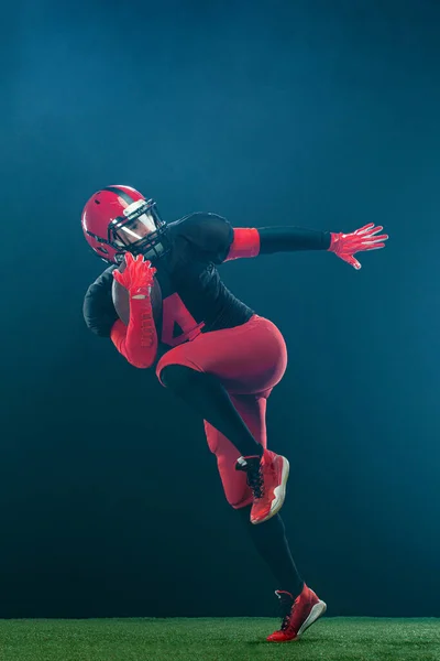 Giocatore di football americano, atleta sportivo in casco rosso su sfondo scuro con fumo. Sport e motivazione carta da parati. — Foto Stock