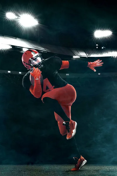 Giocatore di football americano in azione, atleta sportivo in casco rosso sullo sfondo dello stadio. Sport e motivazione carta da parati. — Foto Stock