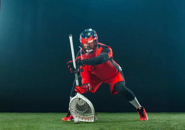 Jogador de lacrosse, atleta desportista de capacete vermelho sobre fundo escuro. Esporte e motivação papel de parede. — Fotografia de Stock